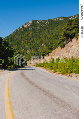 Mountain road section in Crete near Omalos in White Mountains with pine trees. Mountain road section in Crete near Omalos in White Mountains with pine trees. 132069497