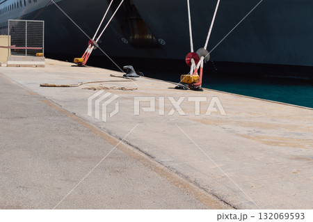 Mooring of a vessel in the port using mooring lines to a bollard on the quay 132069593