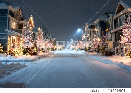 A peaceful street glows with Christmas lights on a snowy winter night. 132069614