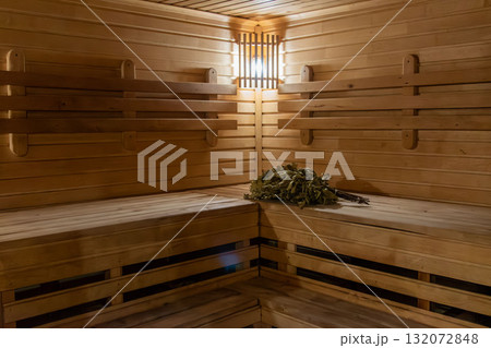 Traditional wooden sauna interior with a sauna whisk or bath broom Traditional wooden sauna interior with a sauna whisk or bath broom 132072848