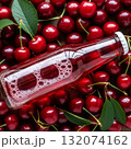 Beverage bottle surrounded by fresh red cherries with bubbling drink inside 132074162
