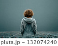 Young woman standing in empty space with gray background and soft light 132074240