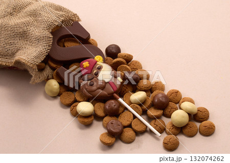 Sinterklaas, St. Nicholas bag filled with a cookies letter S of chocolate and sweets Sinterklaas, St. Nicholas bag filled with a cookies letter S of chocolate and sweets 132074262
