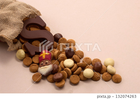 Sinterklaas, St. Nicholas bag filled with a cookies letter S of chocolate and sweets 132074263