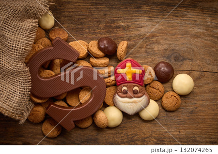 Sinterklaas, St. Nicholas bag filled with a cookies letter S of chocolate and sweets 132074265
