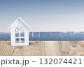 Miniature white house overlooking urban skyline. 132074421