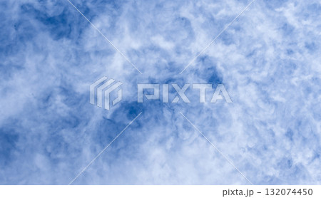 Blue sky filled with soft, wispy clouds creates a calm, expansive mood 132074450