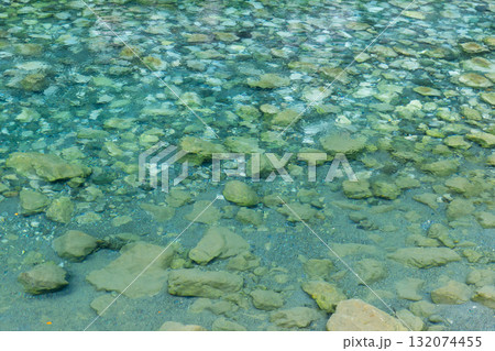 Shoreline scene featuring transparent turquoise water and a bed Shoreline scene featuring transparent turquoise water and a bed 132074455