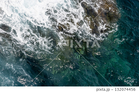 Aerial view of the turquoise sea meeting a rocky coast, natural photo background Aerial view of the turquoise sea meeting a rocky coast, natural photo background 132074456