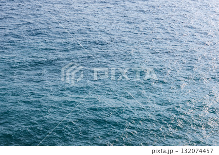 Vast, calm ocean water with gentle ripples and sunlit reflections Vast, calm ocean water with gentle ripples and sunlit reflections 132074457