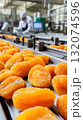 Close-up of dried apricots on industrial conveyor in factory 132074596