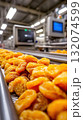 Dried apricots on conveyor belt in modern food processing factory 132074599