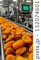 Dried apricots on conveyor belt in modern food processing factory 132074601