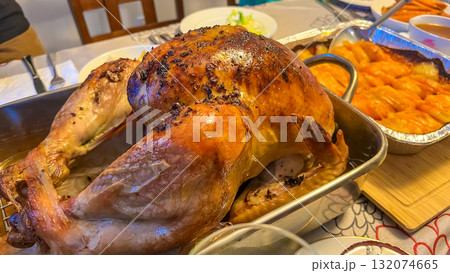 Juicy Thanksgiving turkey served on a festive table, surrounded by delicious side dishes, showcasing a warm and inviting holiday atmosphere Juicy Thanksgiving turkey served on a festive table, surrounded by delicious side dishes, showcasing a warm and inviting holiday atmosphere 132074665