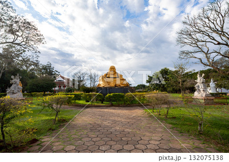 The golden Laughing Buddha, flanked by smaller statues, represents good fortune and joy. Foz do Iguacu, Brazil 132075138