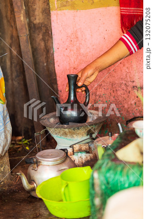 Hand holding a traditional Ethiopian coffee pot, Jebena, during the coffee ceremony in Amhara Region, Ethiopia. 132075208