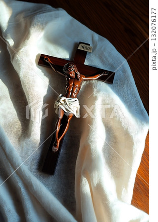 Wooden cross with a man on it is on a white cloth Wooden cross with a man on it is on a white cloth 132076177