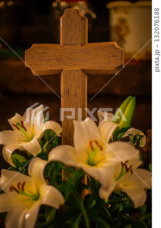 Wooden cross is placed on top of a bouquet of white lilies Wooden cross is placed on top of a bouquet of white lilies 132076188