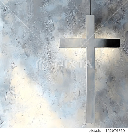 Silver cross is hanging from a wall with a grey background 132076250