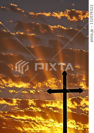 Cross is silhouetted against a beautiful sunset 132076322
