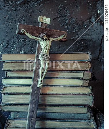 Wooden cross is on top of a stack of books Wooden cross is on top of a stack of books 132076476