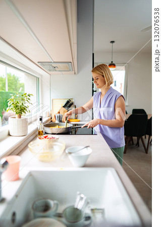 Joyful cooking moment in a modern kitchen setting 132076538