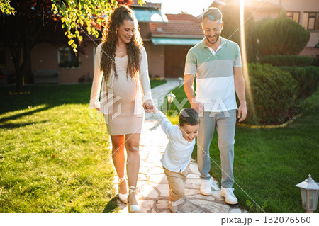Family stroll in the garden during golden hour light Family stroll in the garden during golden hour light 132076560