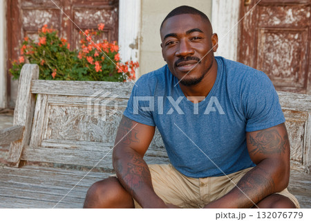 Confident african american man sitting on wooden bench outdoors 132076779