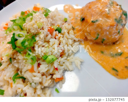 Delicious Rice With Colorful Vegetables and Savory Meatballs on a White Plate 132077745