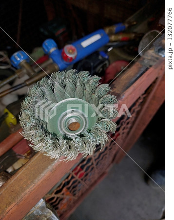 Wire Brush for Grinder Ready for Metal Cleaning in Workshop With Various Tools Nearby 132077766