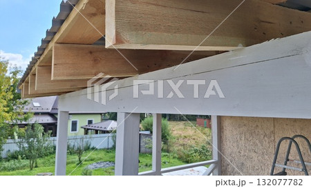 Wooden roof construction detail with timber beams and metal sheeting in residential area 132077782