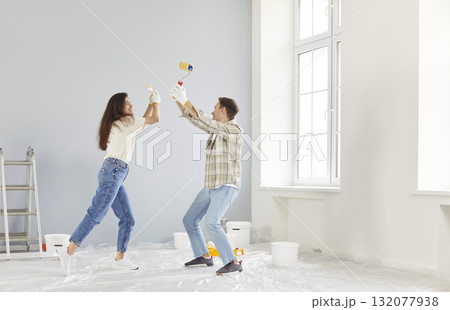 Happy playful couple enjoying home renovation fun, repair after moving into new house, homeowners Happy playful couple enjoying home renovation fun, repair after moving into new house, homeowners 132077938