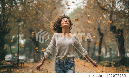 Joyful Woman Embracing the Beauty of Autumn: A Celebration of Freedom, Nature, and the Changing Seasons with Falling Golden Leaves Joyful Woman Embracing the Beauty of Autumn: A Celebration of Freedom, Nature, and the Changing Seasons with Falling Golden Leaves 132077986
