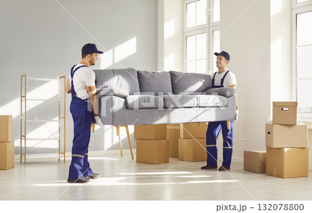 Two workers from delivery service are removing furniture and things from apartment Two workers from delivery service are removing furniture and things from apartment 132078800