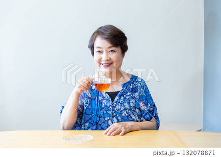 お茶を飲みながらリラックスした表情で談笑するシニア女性 上半身 132078871