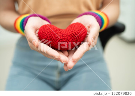 Asian woman holding LGBT heart with rainbow flag. 132079820