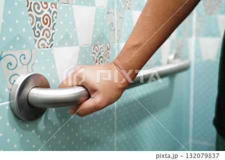 Asian elderly old woman patient use toilet support rail in bathroom, handrail safety grab bar, security in nursing hospital. 132079837