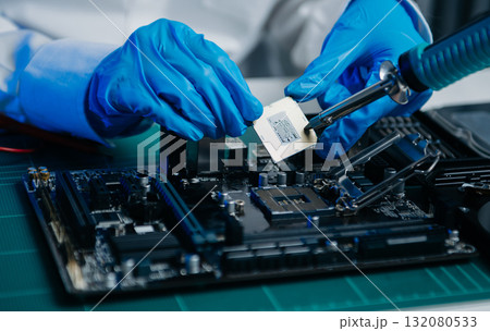 The technician is putting the CPU on the socket of the computer motherboard. electronic engineering electronic repair, 132080533