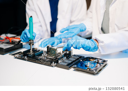 The technician is putting the CPU on the socket of the computer motherboard. electronic engineering electronic repair, electronics measuring The technician is putting the CPU on the socket of the computer motherboard. electronic engineering electronic repair, electronics measuring 132080541
