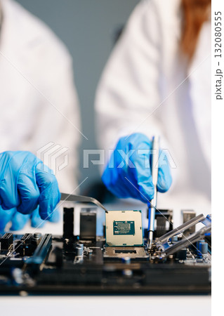 The technician is putting the CPU on the socket of the computer motherboard. electronic engineering electronic repair, electronics measuring 132080555