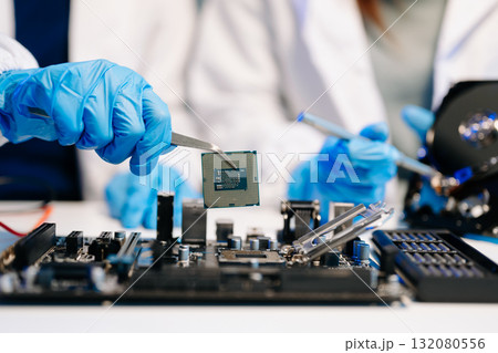 The technician is putting the CPU on the socket of the computer motherboard. electronic engineering electronic repair, electronics measuring 132080556