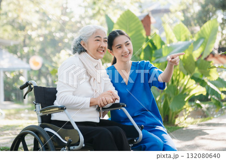 Asian young caregiver nurse support senior older male walking outdoors. Specialis doctor help and take care of elderly mature. 132080640