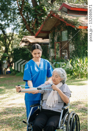 Asian physiotherapist helping elderly woman patient stretching arm during exercise correct with dumbbell in hand during training hand with patient Back problems in the garden. Asian physiotherapist helping elderly woman patient stretching arm during exercise correct with dumbbell in hand during training hand with patient Back problems in the garden. 132080671