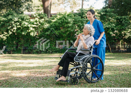 Asian physiotherapist helping elderly woman patient stretching arm during exercise correct with dumbbell in hand during training hand with patient Back problems in the garden. Asian physiotherapist helping elderly woman patient stretching arm during exercise correct with dumbbell in hand during training hand with patient Back problems in the garden. 132080688