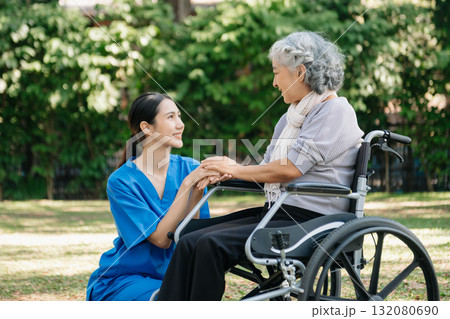 Asian physiotherapist helping elderly woman patient stretching arm during exercise correct with dumbbell in hand during training hand with patient Back problems in the garden. 132080690