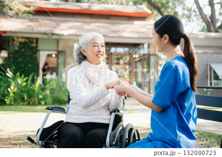 Asian young caregiver nurse support senior older male walking outdoors. Specialis doctor help and take care of elderly mature. 132080723