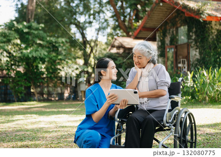 Asian old woman sitting on a wheelchair outdoors in the park Have pain in the arms, wrists and body Asian old woman sitting on a wheelchair outdoors in the park Have pain in the arms, wrists and body 132080775