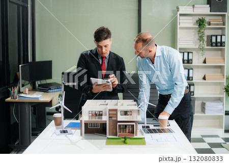 Meeting of architects, designers, and developers creating innovative, sustainable housing projects using building models and digital tools. 132080833