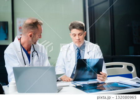 Diverse team of doctors and specialists brainstorming with digital tools, discussing test results and planning in hospital Diverse team of doctors and specialists brainstorming with digital tools, discussing test results and planning in hospital 132080965