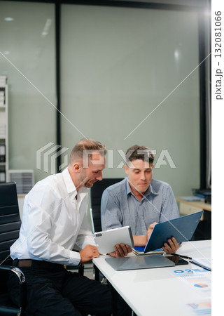 Two business workers talking on the smartphone and using laptop Two business workers talking on the smartphone and using laptop 132081066